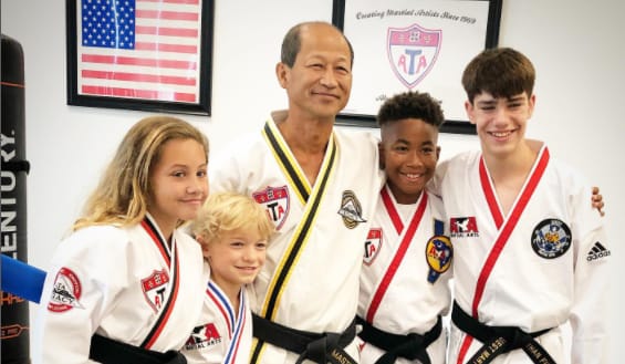 Ethan Fineshriber with his martial arts coach and fellow mates

