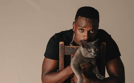 Bonko Khoza in a modeling pose with a cat