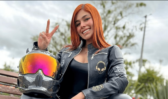 Yineth Medina riding on a bike and showcasing a victory sign