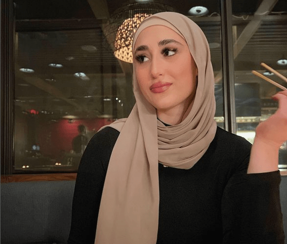 Alia Deeb in a black dress and grey headscarf