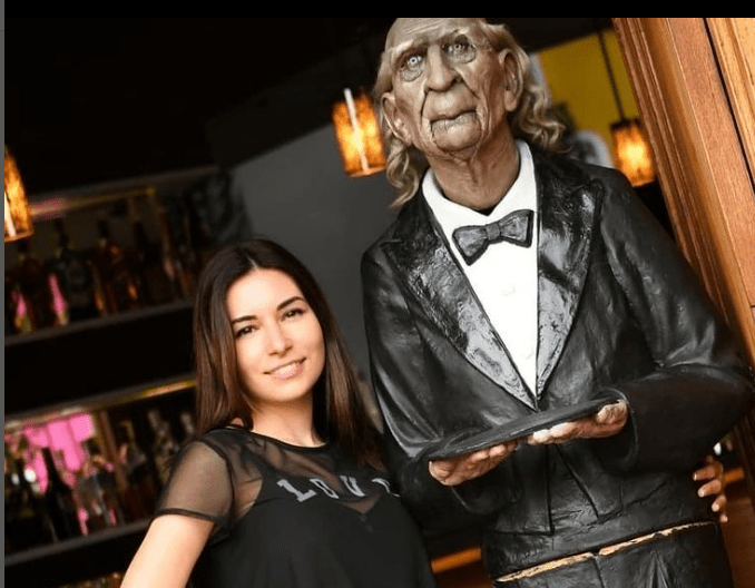 Alinity Divine taking pictures with a statue