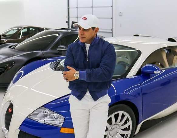 Manny Khoshbin standing in front of his pricey car