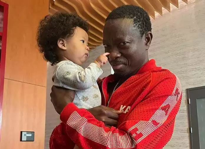 Michael Blackson playing with a baby