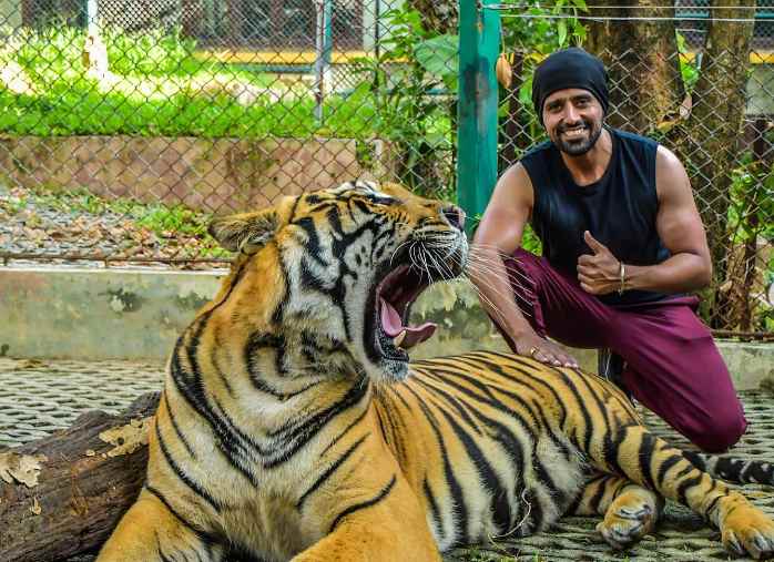 Anil Charanjeett taking pictures with a tiger